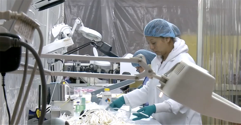 Two women in lab coats working on a project.