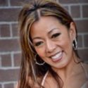 A woman with long brown hair smiles for the camera.